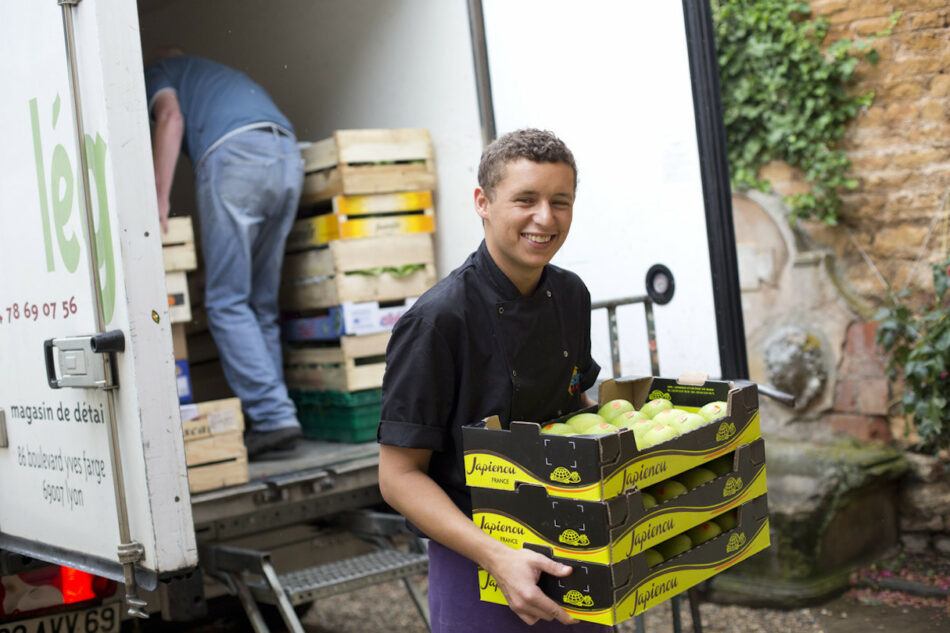 Contiki Chateau, young man holding box of local veg