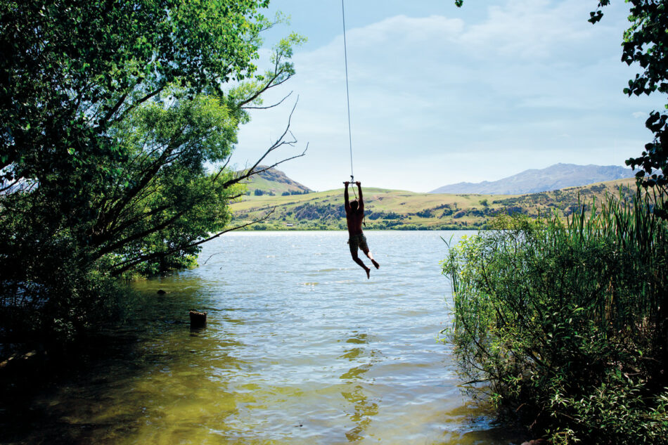 A person is suspended from a rope in a body of water, facing imminent travel changes.