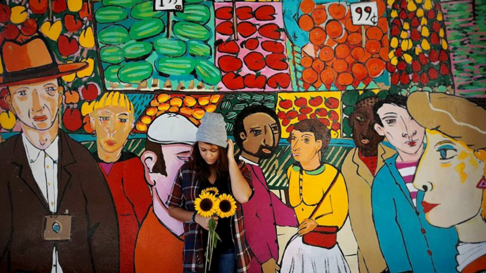 A mural depicting a group of people in front of a market.