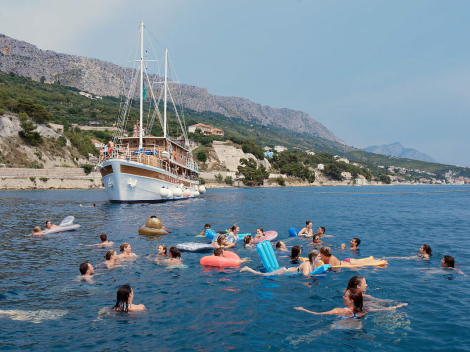 Group swimming near a boat - things to do in croatia