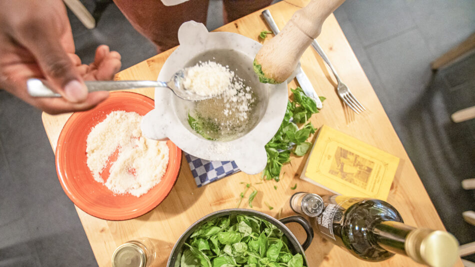 A person is mixing ingredients on a wooden table.