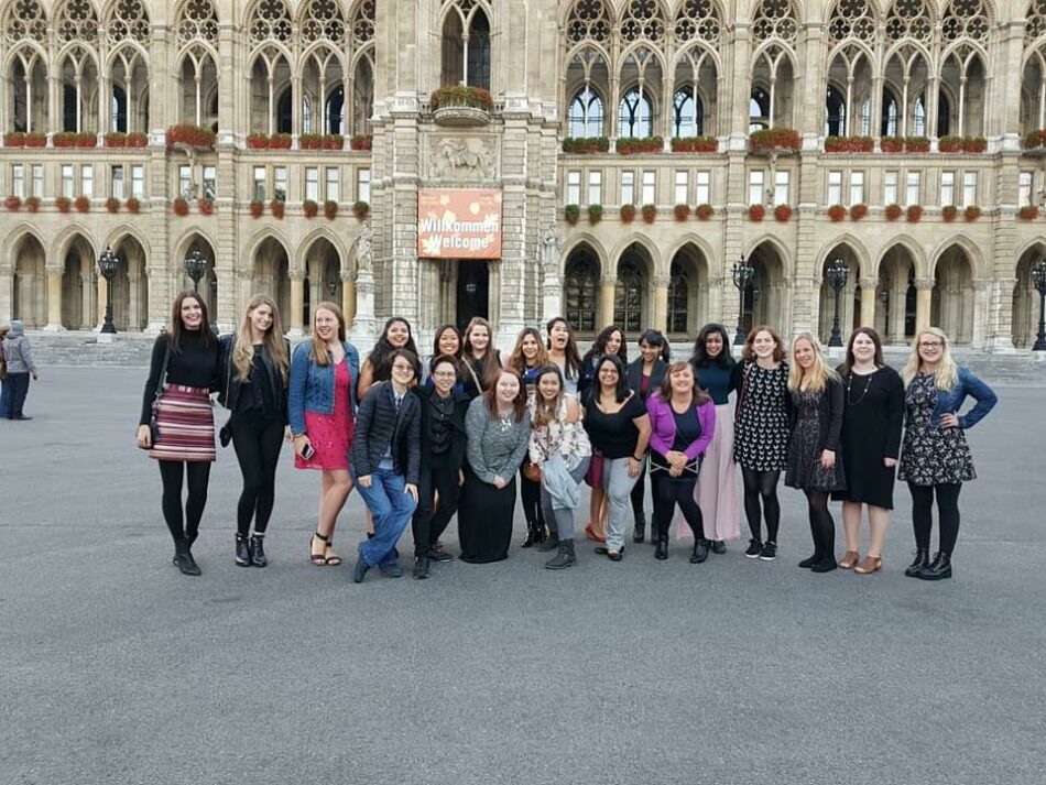 A group of women posing in front of an ornate building, learning life lessons.