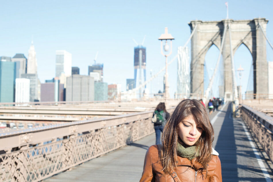 girl walking on Brooklyn bridge in new york