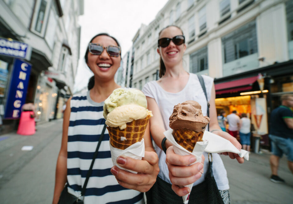 Two women holding ice cream cones on a street, representing the #contikigirlsquad.