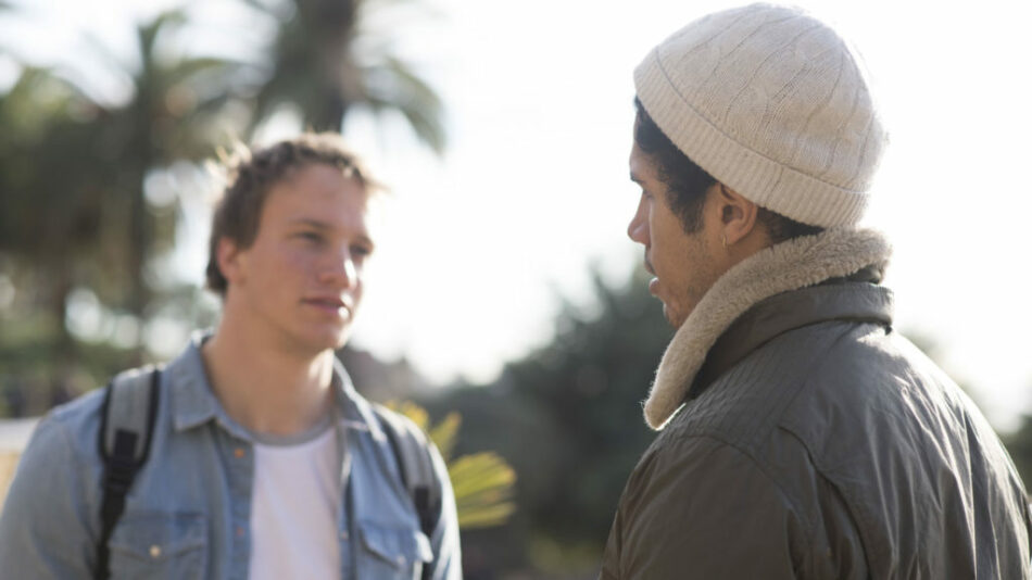 Two men experiencing reverse culture shock while conversing in a park.