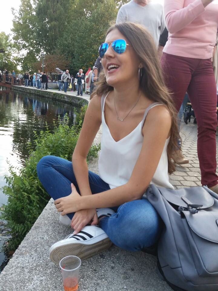 A woman sitting on a bench near a river in Budapest.