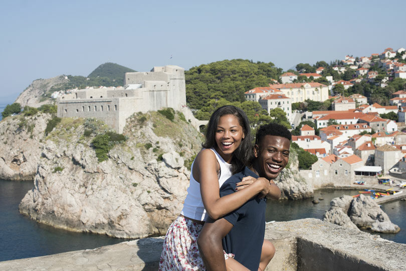 A young couple posing in front of a castle during their Contiki sailing adventure in Croatia.