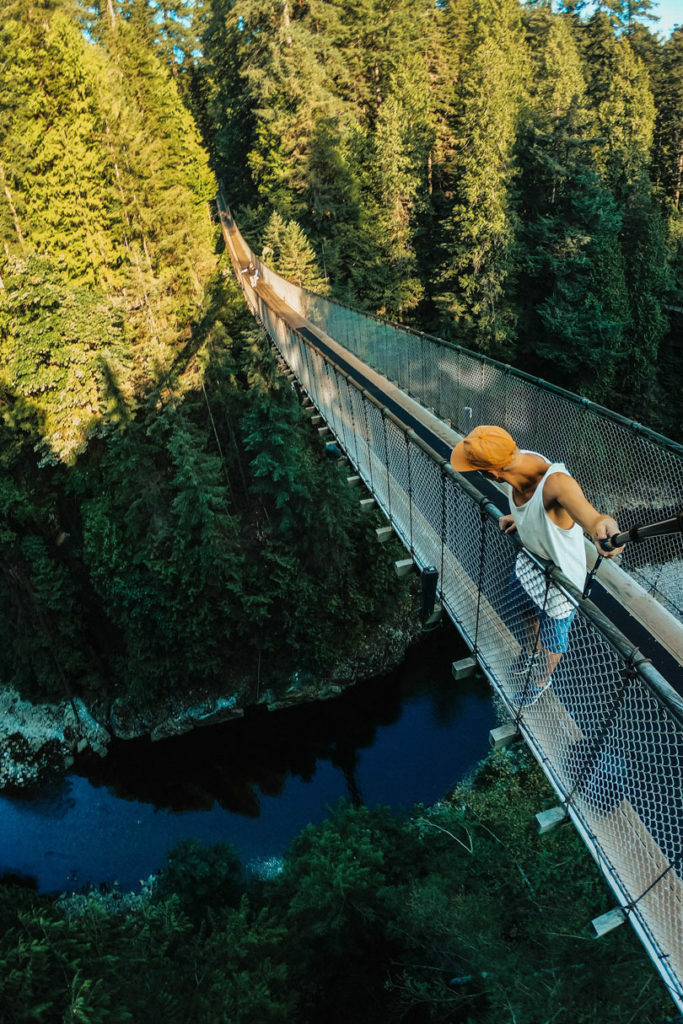 A man is standing on a suspension bridge in Canada.