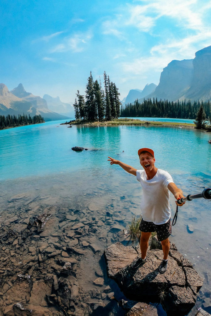 A man standing in front of a lake during group travel in Canada.