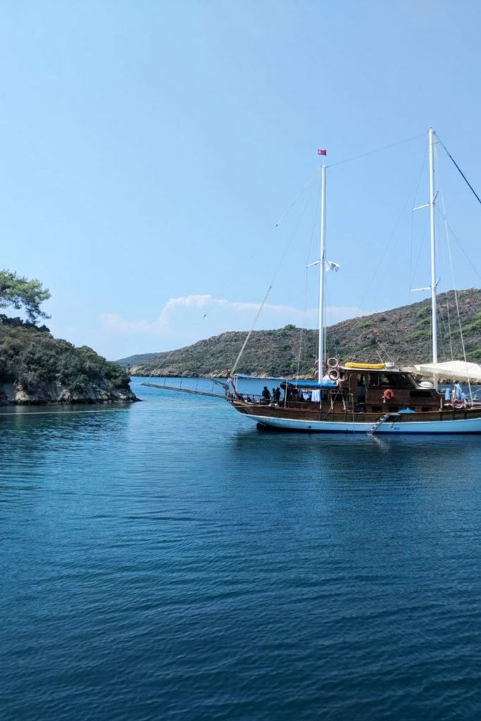 A sustainable sailboat floats near an island, promoting zero waste travel.