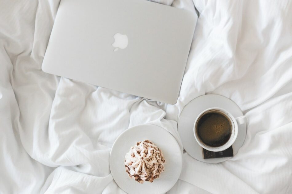 A bed with a laptop and a cup of coffee, envisioning success post-covid.