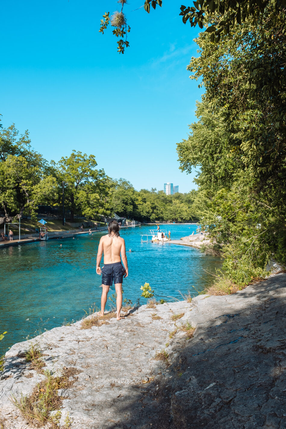 A man is standing near a body of water in Austin.