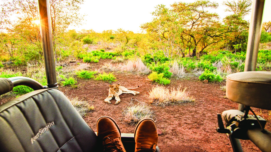 A person's feet rest on the seat of a vehicle.