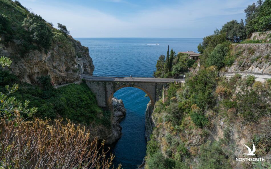 A bridge over a cliff near the ocean in Italy.