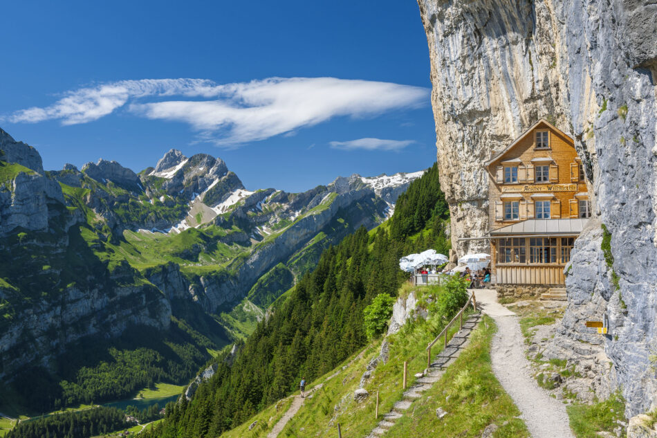 Visit Switzerland to see a house on the side of a cliff.