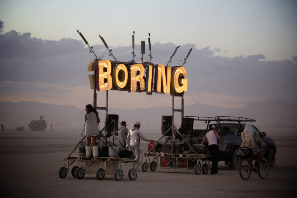 A group of people standing in front of a sign that says Burning Man.