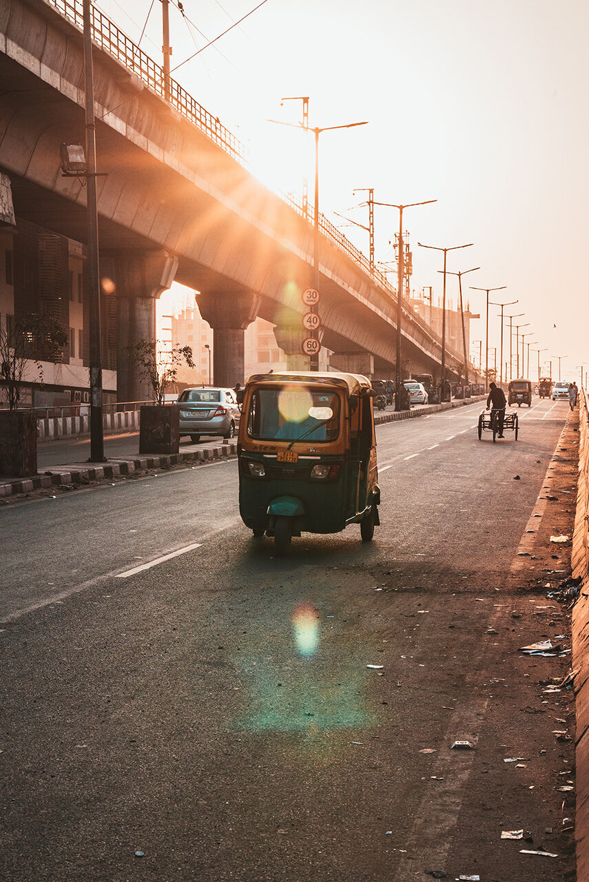 A man driving a rickshaw in an Asian city.