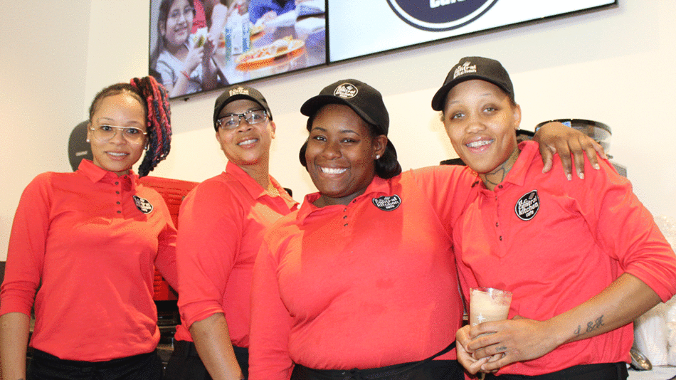 Four women in red shirts, capturing an exquisite us food experience in a picture.