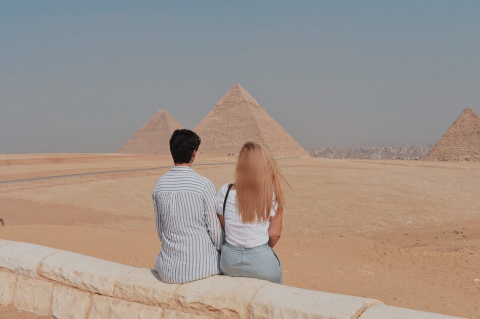 Two people looking at the pyramids in giza, egypt.