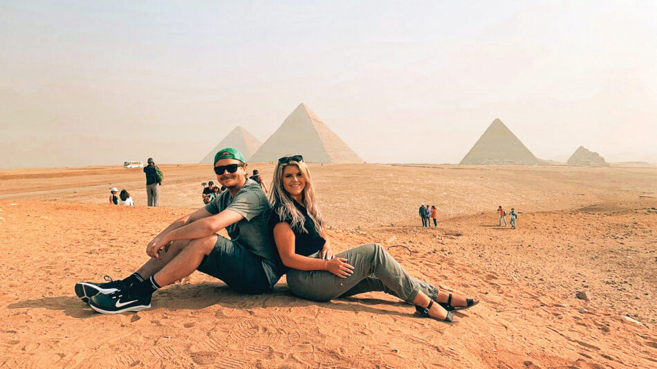 Egypt pyramids of Giza two friends sitting and taking photo