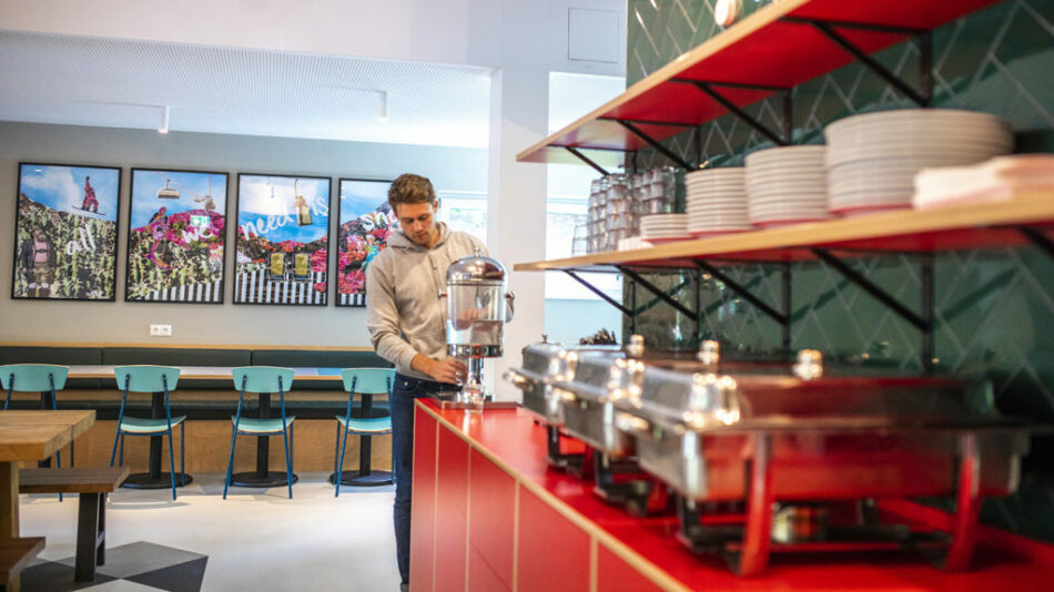 A man standing at the counter of Gasthof Schoneck.