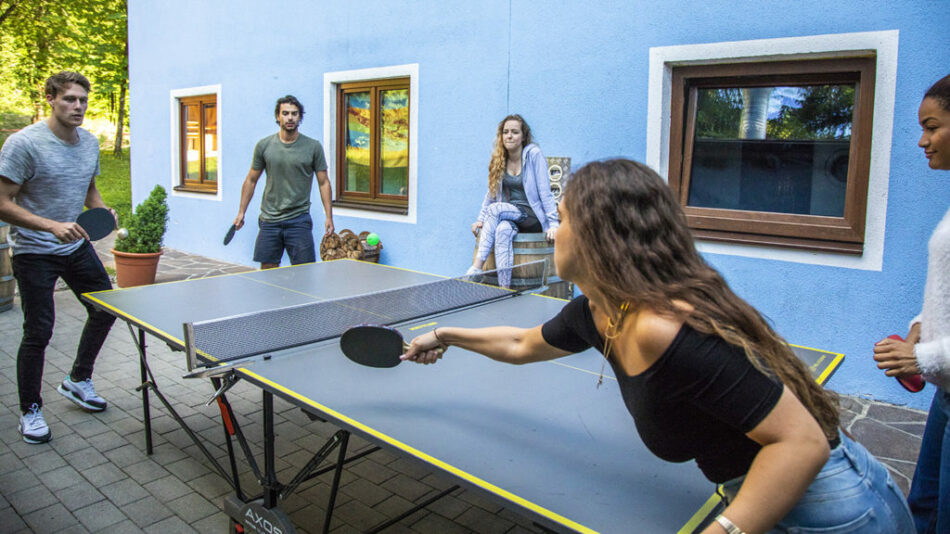 A group of people playing ping pong at Gasthof Schoneck.