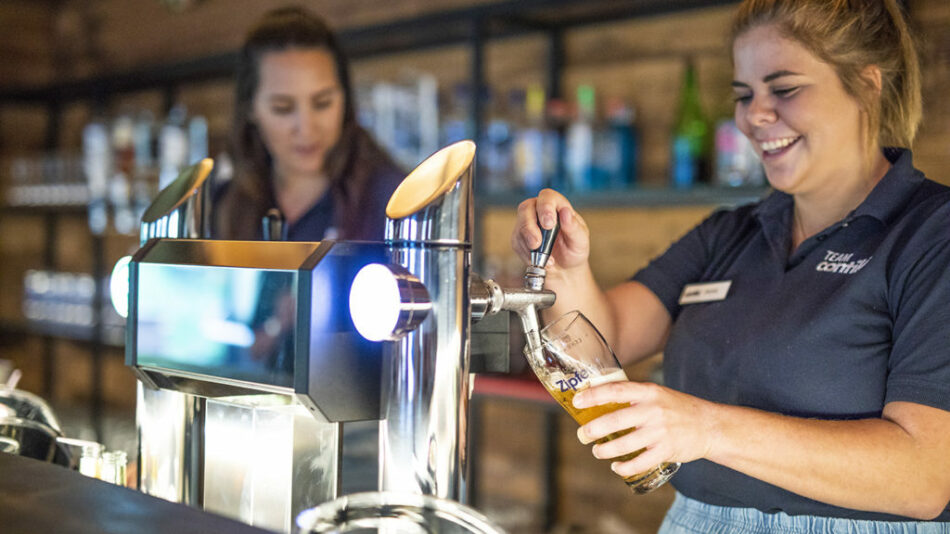 A woman is pouring a beer at Gasthof Schoneck.