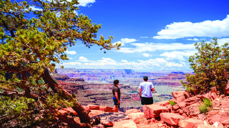 Two people standing on a rocky path at one of the best national parks.