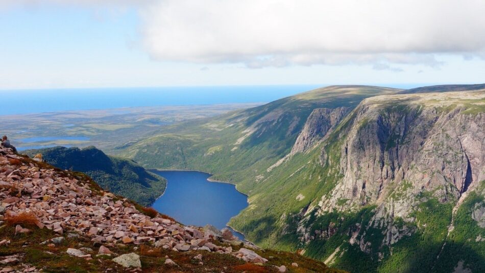 A view from the top of a mountain overlooking a lake.