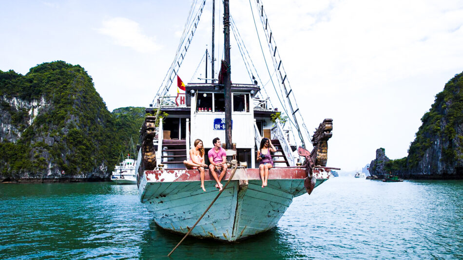 A group of people having a Vietnam experience, sitting on the back of a boat.