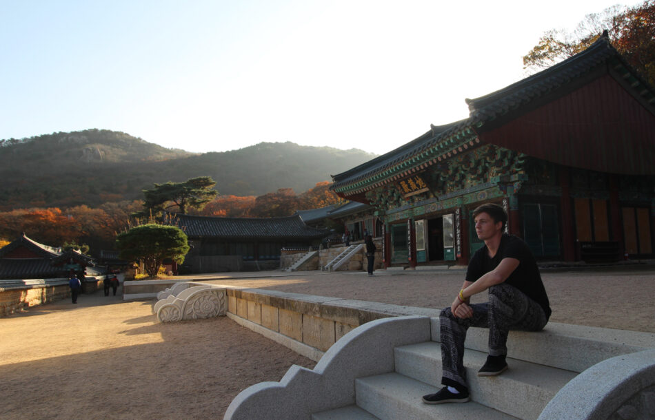 A backpacker sitting on the steps of a building.