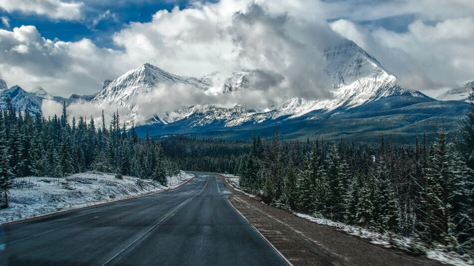 A road with snowy mountains in the background.