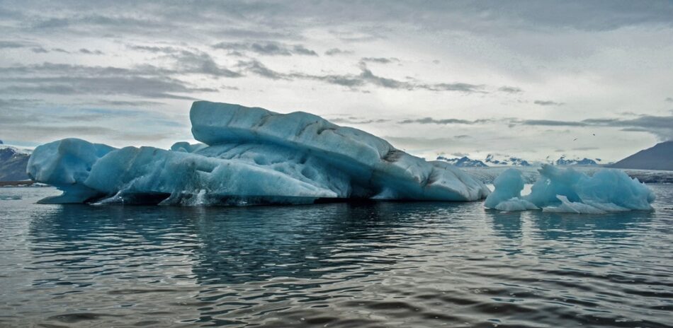 A magnificent iceberg, one of the must-see destinations for 2016, majestically floating in a crystal-clear body of water.