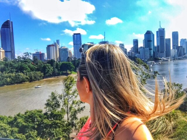 A woman moves to a new city for a job and finds inspiration by looking out over a river with the skyline in the background.