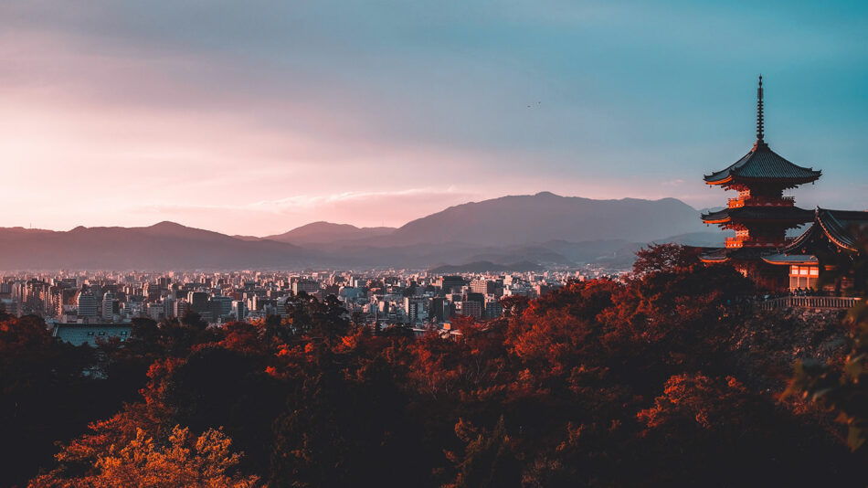 Japanese pagoda at sunset with mountains in the background, one of the 15 best places to visit in October.