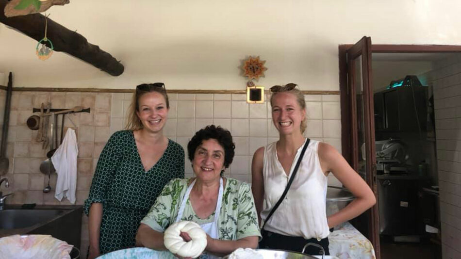 Three women posing for a photo in a kitchen.