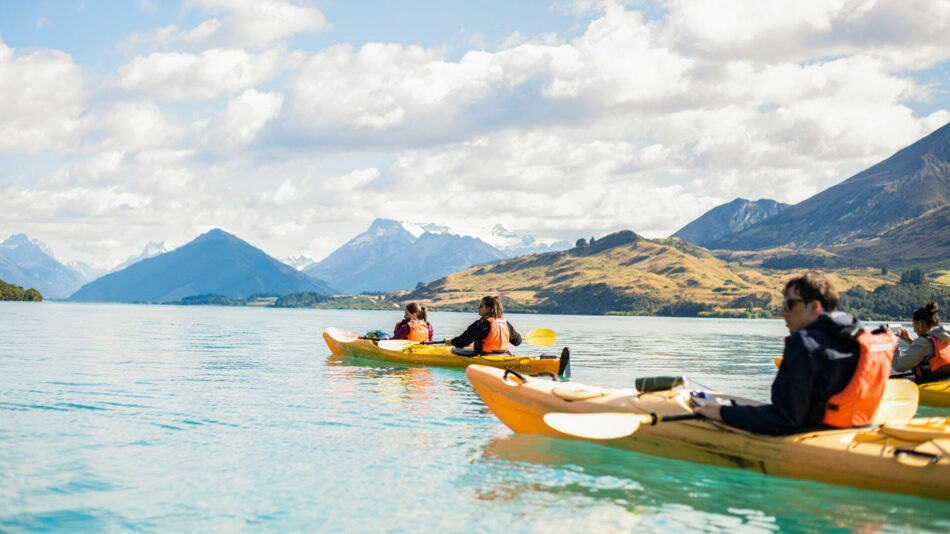 A group of people kayaking on a lake in new zealand.