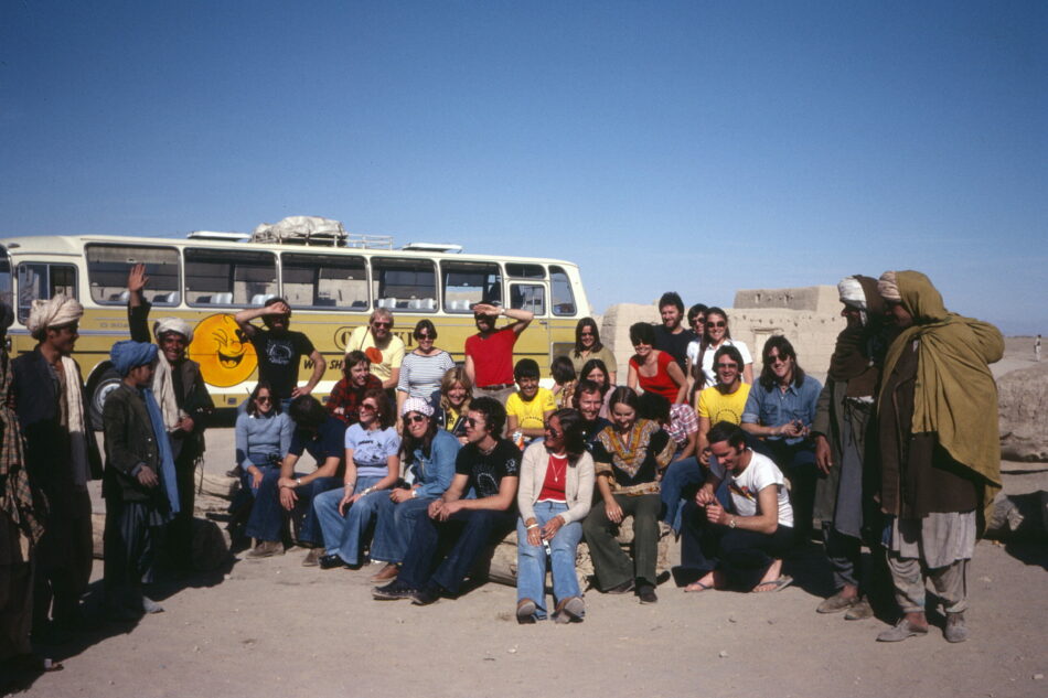 A group of people posing in front of a bus.