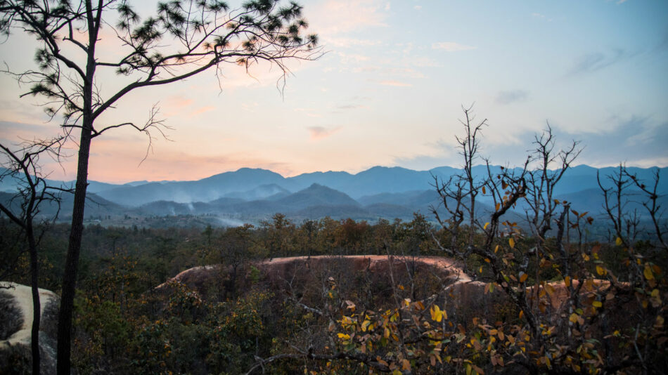 One of the most beautiful destinations in Thailand, a mountain range with trees and rocks in the foreground.