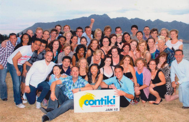 A group of people posing for a photo in front of mountains in New Zealand.