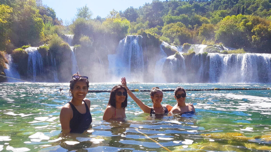 A group of people near a waterfall on one of the Croatia islands.