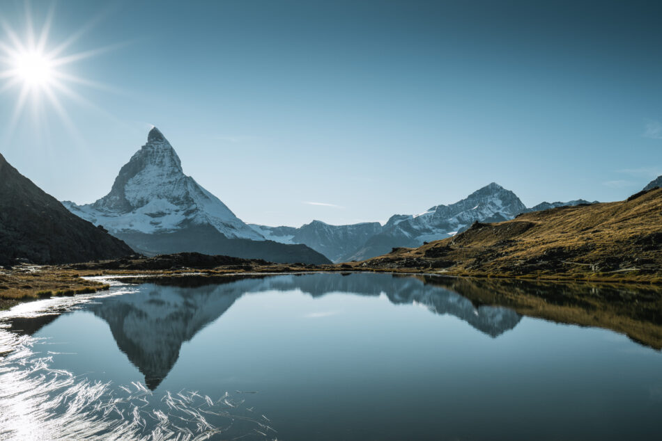 A majestic mountain reflected in a crystal-clear lake, perfect for visiting Switzerland.