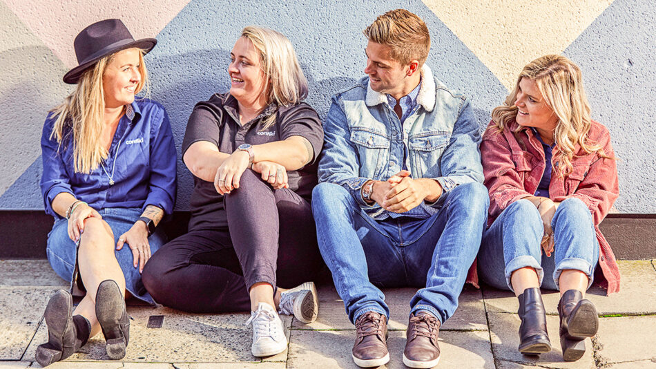 A group of contiki trip managers sitting in front of a wall.