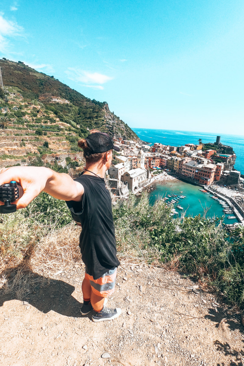 A man standing on a hill overlooking a town.