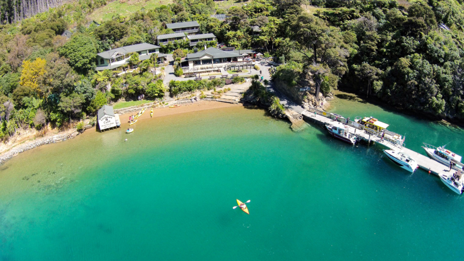 An aerial view of a house with a boat docked in the water.