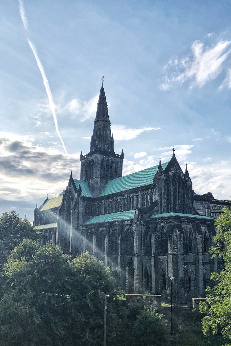 A large cathedral with a green spire in the background.