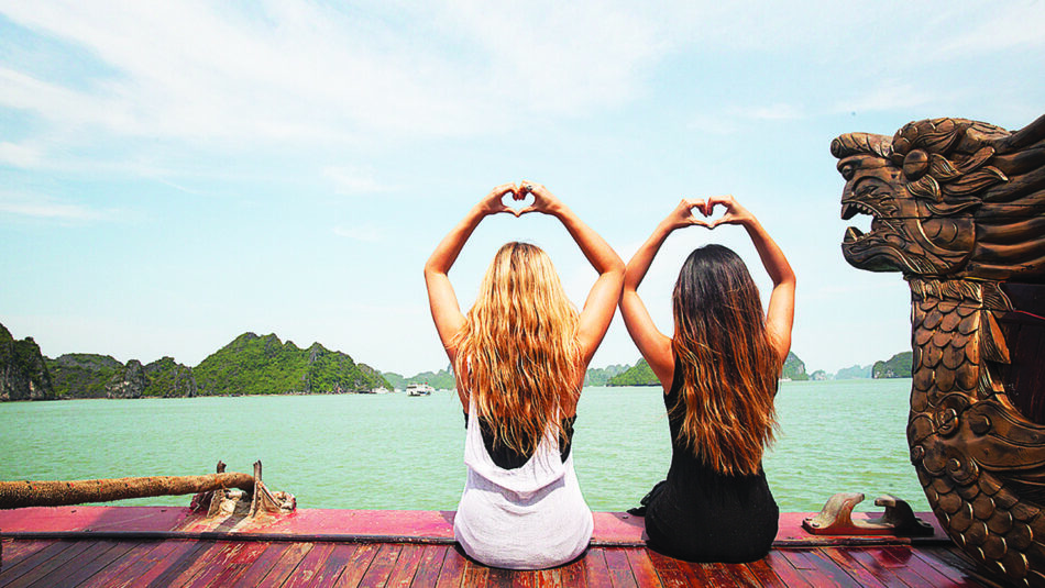 Two women on a solo travel adventure in Vietnam, enjoying their time aboard a boat.