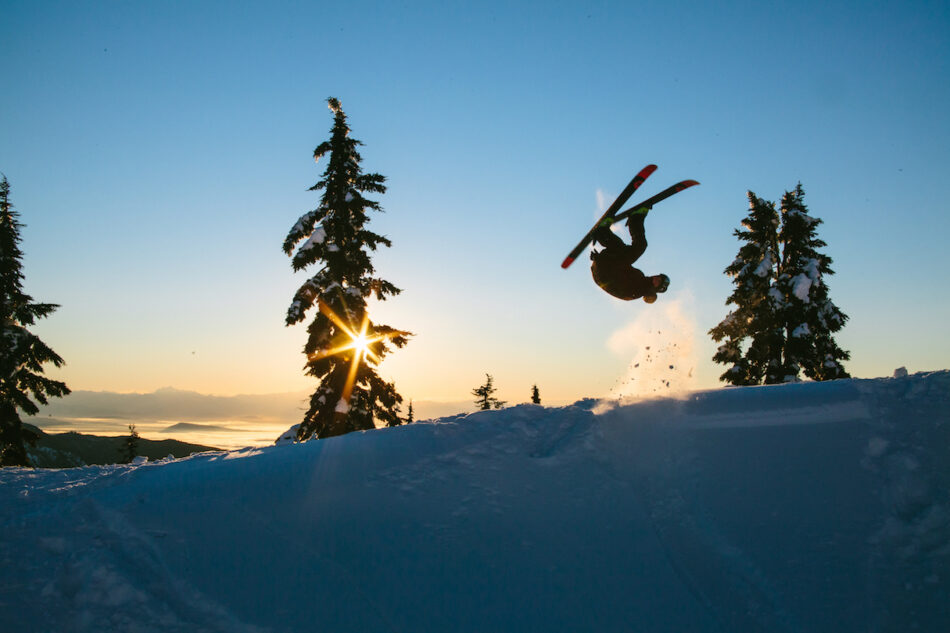 A person doing a jump on skis in the snow.