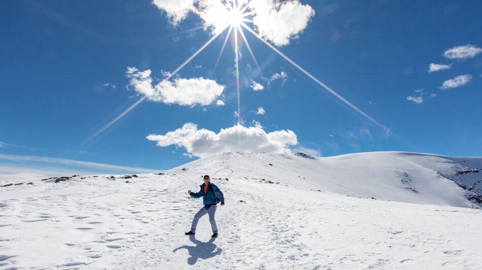 A person walking on a snow covered mountain.