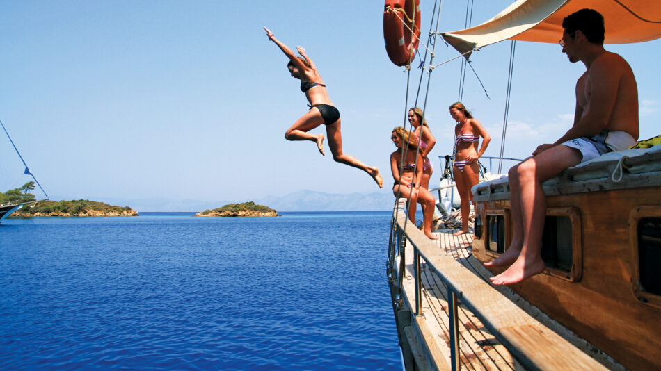 Adventures in Europe - Image of a girl jumping off a sailing boat in Turkey